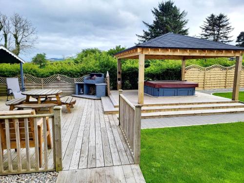 a wooden deck with a gazebo and a picnic table at Woodside guest house in Castlerock