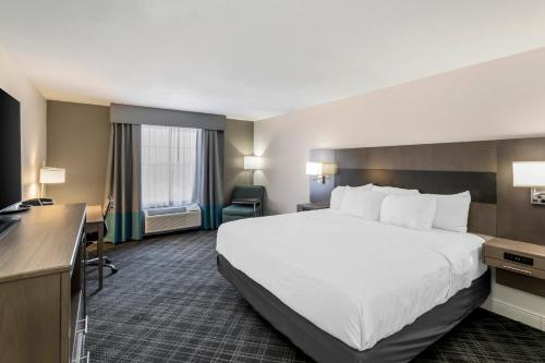a hotel room with a large bed and a desk at Comfort Inn & Suites in Andrews