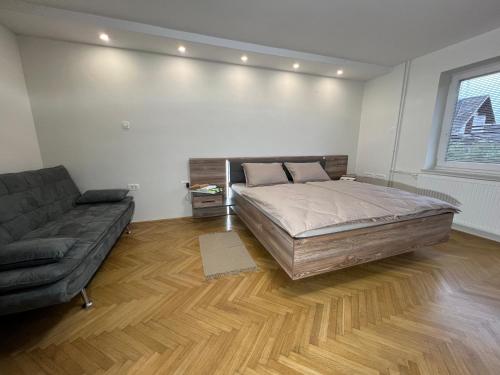 1 dormitorio con 1 cama grande y 1 sofá en Mici's Apartments, en Visoko