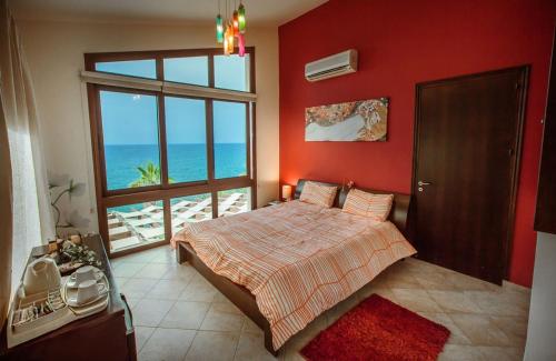 1 dormitorio con 1 cama y vistas al océano en Kallinousa Beach Villa, en Pomos