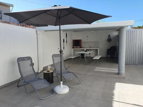 an umbrella on a patio with chairs and a table at Casa da Avó Laurinda in Valado dos Frades