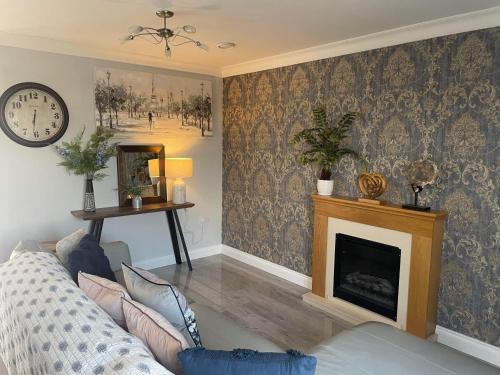 a living room with a couch and a fireplace at Number 1 Longstone Court in Haverfordwest