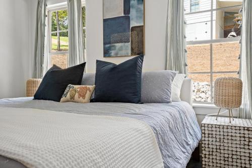 Un dormitorio con una cama con almohadas azules y una ventana en Twilight House at Kowaliga Bay, en Eclectic