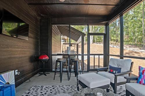 un porche cubierto con sillas y mesa en Twilight House at Kowaliga Bay, en Eclectic