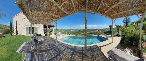 Castignano的住宿－Lemonvilla - Rustico in Panoramalage，享有别墅内游泳池的顶部景致