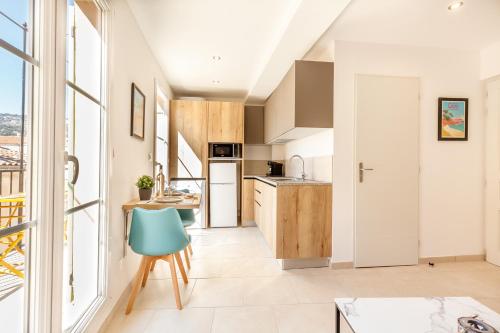 une cuisine avec une table et une chaise bleue dans l'établissement Roche 4, à Toulon
