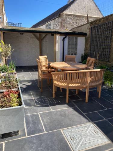 a patio with a wooden table and chairs on a patio at Serendipity in Kirkcudbright