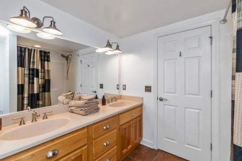 baño con 2 lavabos y espejo grande en The Clo Cottage on Lake Martin, en Dadeville