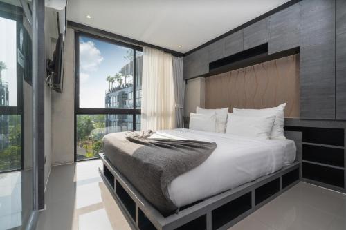 1 dormitorio con cama grande y ventana grande en 5 Stars Facilities Condo Kamala Beach en Kamala Beach