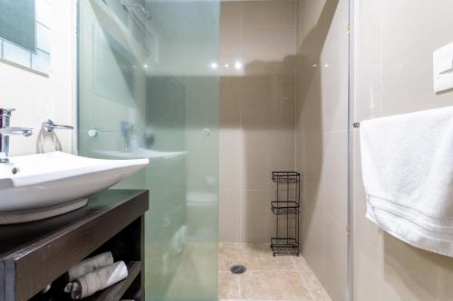 W łazience znajduje się szklana kabina prysznicowa i umywalka. w obiekcie Suites 259 Condesa w mieście Meksyk