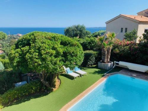 une arrière-cour avec une piscine, des arbres et une maison dans l'établissement Lord of Sainte-Maxime, à La Garonnette-Plage