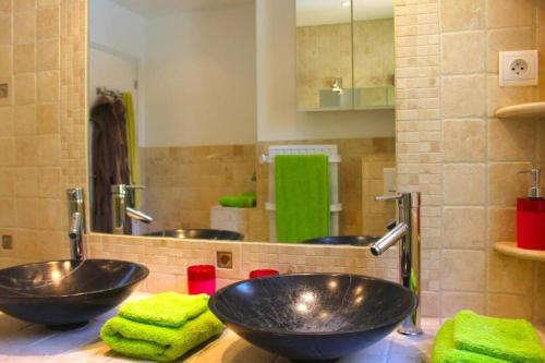 La salle de bains est pourvue de 2 lavabos et de serviettes vertes. dans l'établissement Lord of Sainte-Maxime, à La Garonnette-Plage