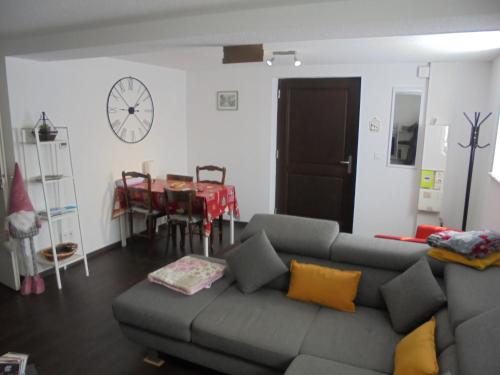 uma sala de estar com um sofá cinzento e uma mesa em Appartement F2 de 50m2 équipé à 5min de Colmar em Horbourg