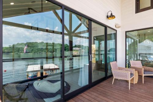 a balcony with glass doors and a view of the water at Sunset Rock at Lake Martin in Alexander City