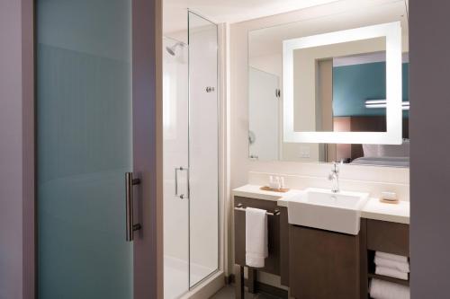uma casa de banho com um lavatório e um espelho em SpringHill Suites by Marriott San Diego Downtown/Bayfront em San Diego