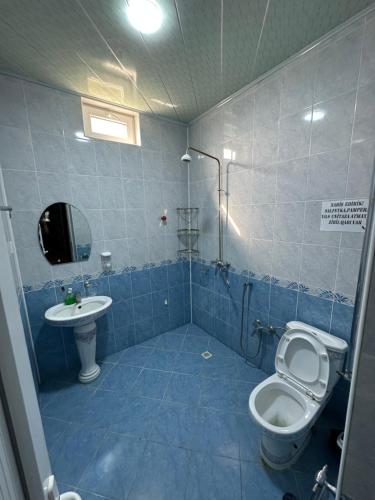 uma casa de banho em azulejos azuis com um WC e um lavatório em Gabala Garden Harmony em Gabala