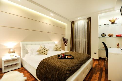 a bedroom with a large bed with a tray on it at Main Street Studio and Rooms in Zadar