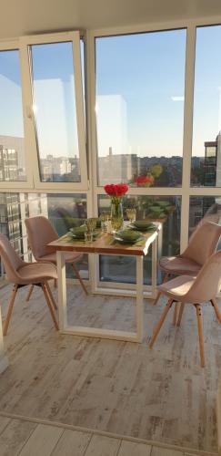 a white table and chairs in a room with windows at Dream town Apartaments біля залізничного вокзалу in Luts'k