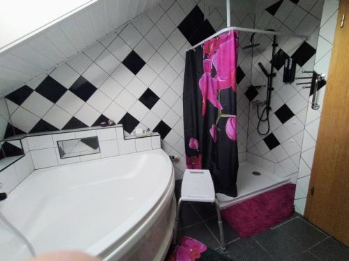 a bathroom with a toilet and a black and pink shower curtain at Chez l'Eveline Chambre Libellule in Les Bois