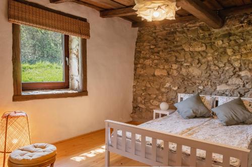 sypialnia z łóżkiem i kamienną ścianą w obiekcie Rusztika Country Home w mieście Lesencetomaj