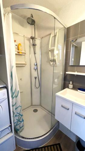 une douche avec une porte vitrée dans une salle de bain dans l'établissement Charmant appartement classé et son jardin à 2 pas de la plage - AC Fibre Parking, à La Grande Motte