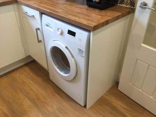 a washer and dryer under a counter in a kitchen at ChurstonBnB, private flat within family home, Bolton in Lostock