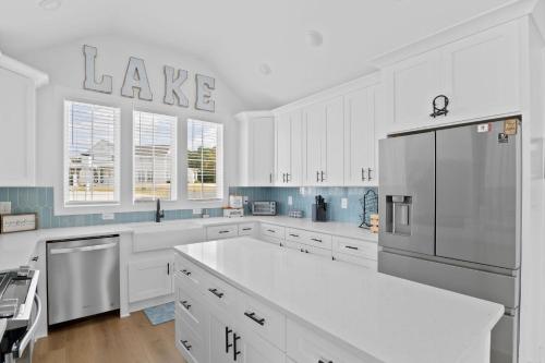 a kitchen with white cabinets and a stainless steel refrigerator at Lake Happy in Dadeville
