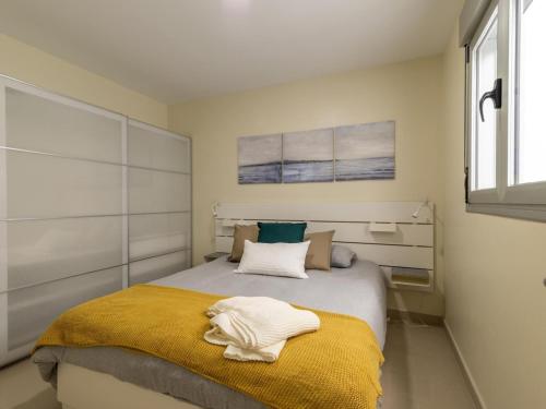 a bedroom with a large bed with a yellow blanket at Nuevos Lightbooking Livian Suites Las Palmas in Las Palmas de Gran Canaria