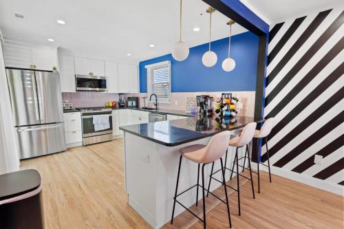 a kitchen with white cabinets and a counter with stools at Stylishly Renovated 5-Bedroom Home in AC - Perfect for Groups and Families in Atlantic City