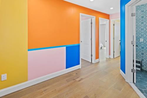 a hallway with orange and blue walls at Stylishly Renovated 5-Bedroom Home in AC - Perfect for Groups and Families in Atlantic City