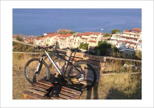 a bike parked on a bench near the ocean at VatiKurca in San Nicola Arcella