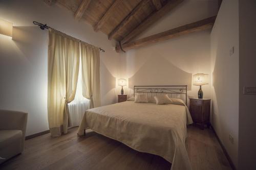 a bedroom with a bed and two lamps and a couch at Country House Giusti Abazia in Nervesa della Battaglia