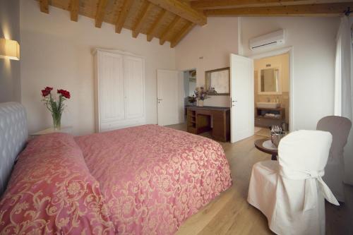 a bedroom with a pink bed and a desk with flowers at Country House Giusti Abazia in Nervesa della Battaglia