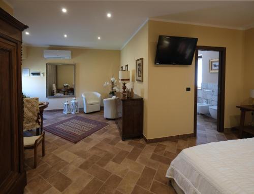 a hotel room with a bed and a television on the wall at Tenuta Aranuova in Vercelli