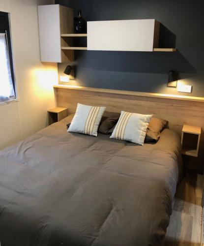 un lit avec deux oreillers dessus dans une chambre dans l'établissement A l ombre des pins 40 Mobil home 211, à Saint-Julien-en-Born
