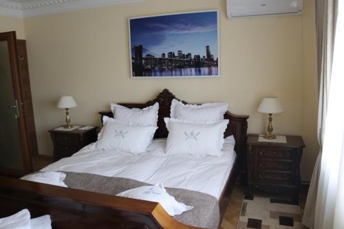 a bedroom with a bed with white sheets and pillows at Casa Dobra in Dobra