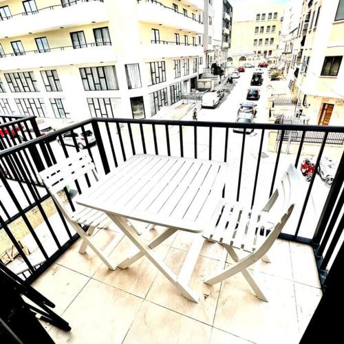 a white table and two chairs on a balcony at Gzira Smart 1 Bedroom Apartment in Il-Gżira