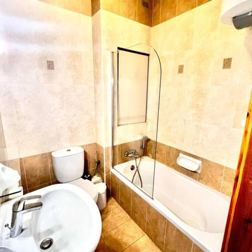 a bathroom with a toilet and a sink and a tub at Gzira Smart 1 Bedroom Apartment in Il-Gżira