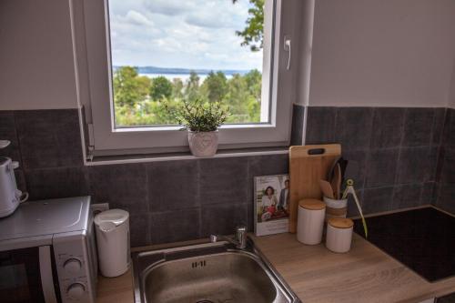 a kitchen with a sink and a window at Turquoise Lake Guesthouse Balaton in Balatonszárszó