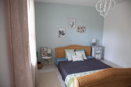 a bedroom with a bed and a chandelier at Turquoise Lake Guesthouse Balaton in Balatonszárszó