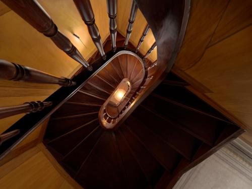 a wooden spiral staircase with a light at the top at Monument Hotel in Athens