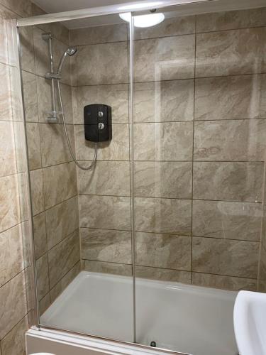 una doccia con porta in vetro in bagno di 228 Cinderhill Road a Nottingham
