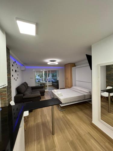 a bedroom with a bed and a living room at Hany apartment Ducado 2-I in Benidorm