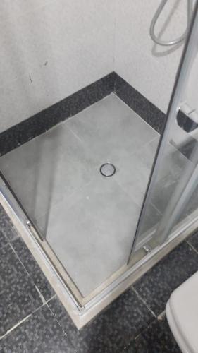 a shower stall with a drain in the floor at Abu Arena Hall in Baku