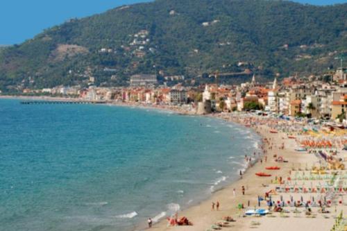 grupa ludzi na plaży z oceanem w obiekcie Bilocale a 15 min da Alassio e Albenga w mieście Ranzo-Borgo