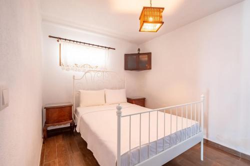 a bedroom with a white bed and a crib at Impressive House near Paradise Bay in Bodrum in Golturkbuku