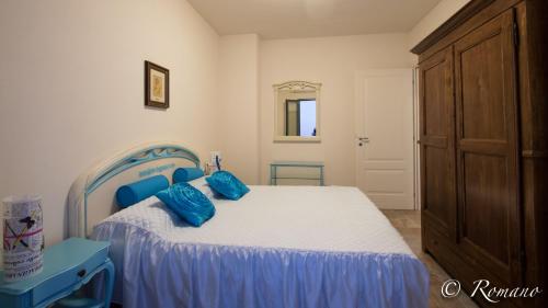 a bedroom with a bed with blue pillows on it at Villa Montefontane in Camporosso