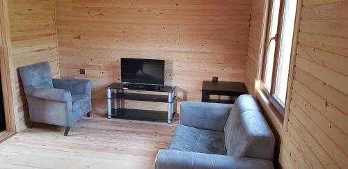 ein Wohnzimmer mit einem Sofa und einem TV in der Unterkunft Olympos wood house in Kumluca