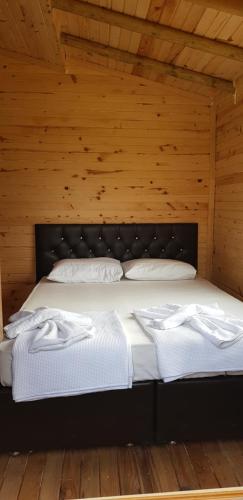 a bed in a wooden room with two white pillows at Olympos wood house in Kumluca