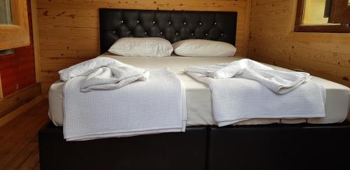 ein Schlafzimmer mit einem Bett mit zwei Handtüchern darauf in der Unterkunft Olympos wood house in Kumluca